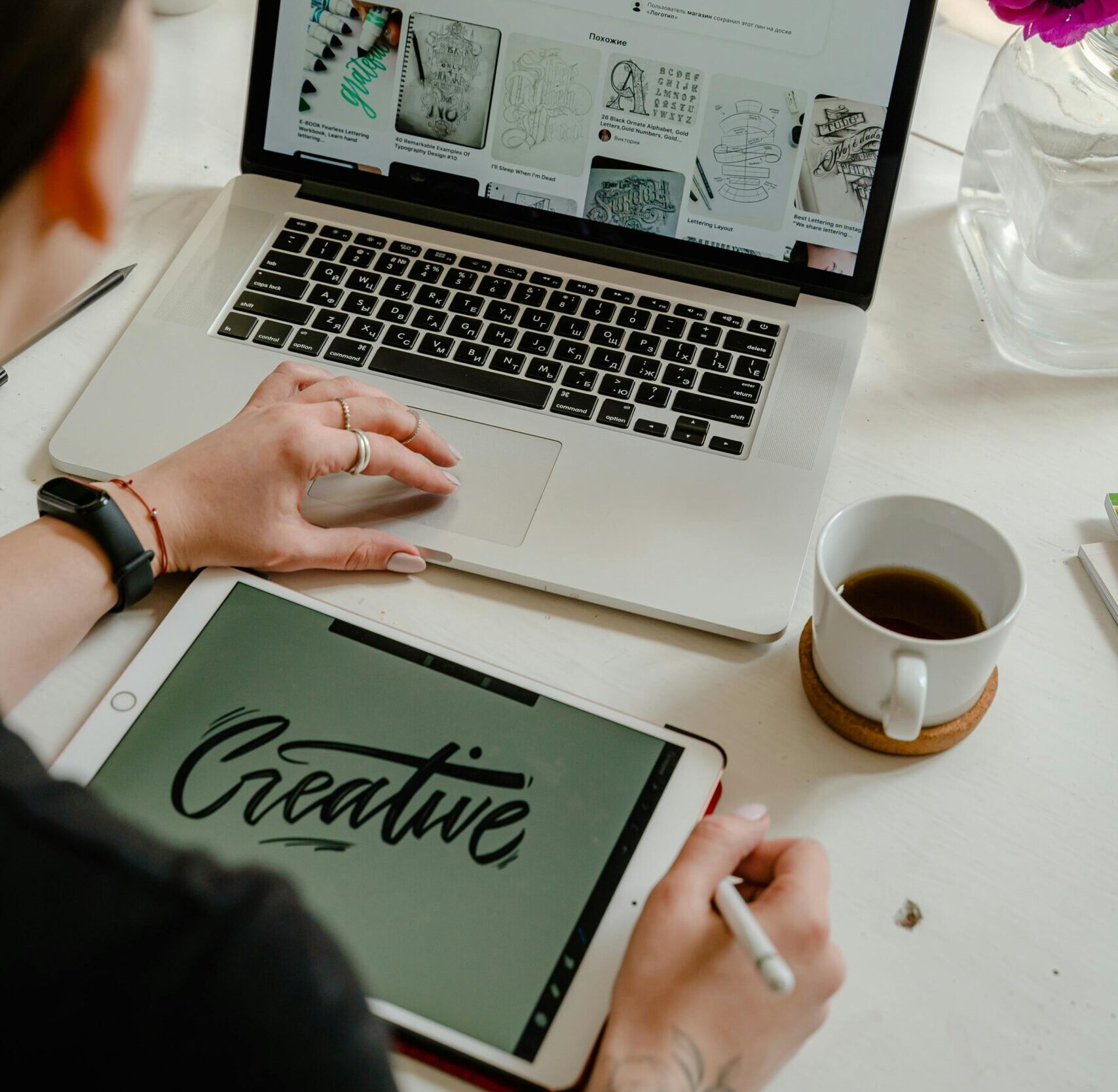 Creative work session featuring a woman using a tablet and laptop for design projects.